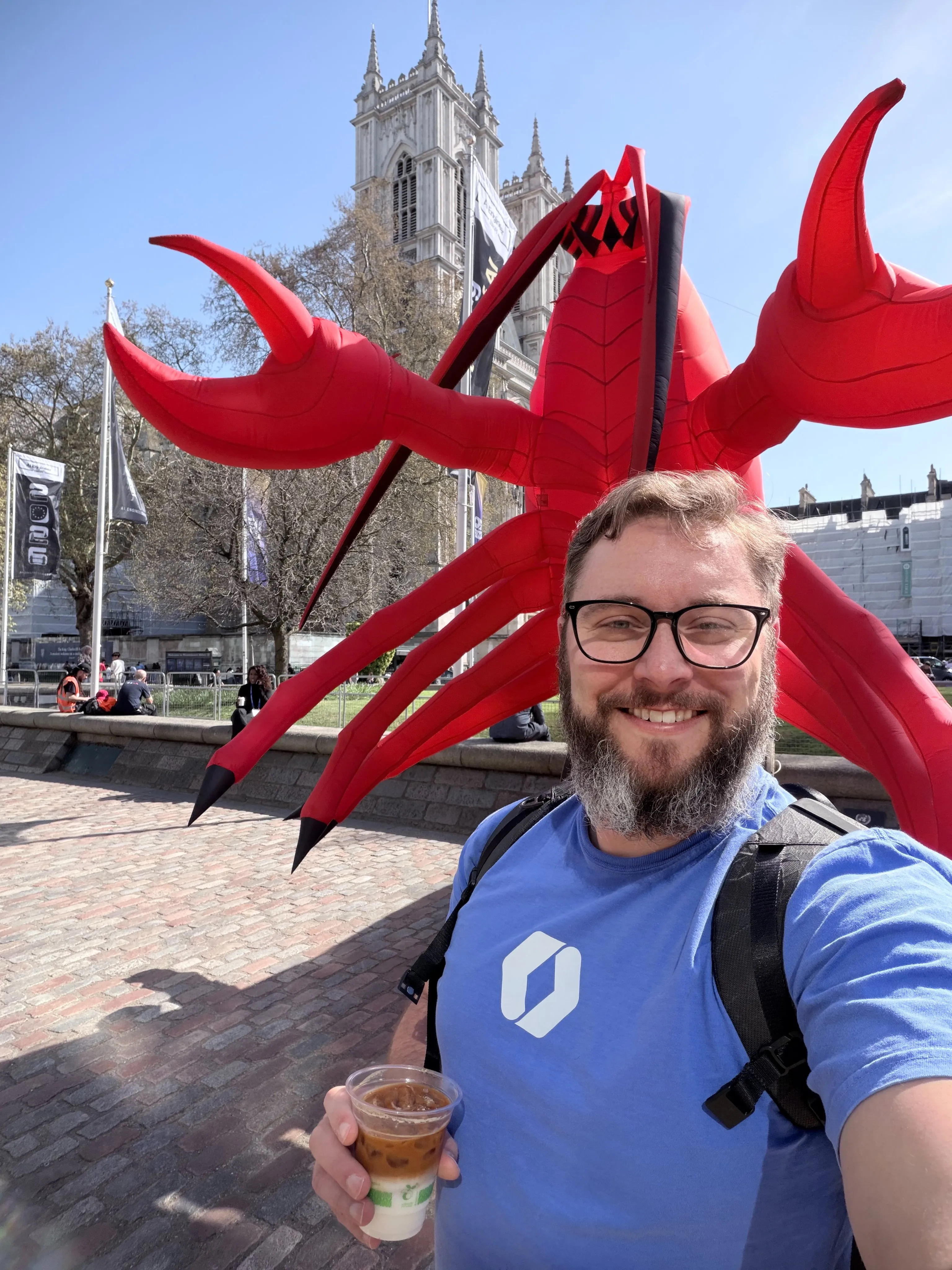Nick outside in London with a giant red sculpture and Westminster Abbey in the background